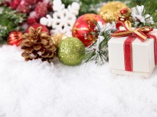 Christmas border with decorations, pine cone and gift on the snow. Space for copy.